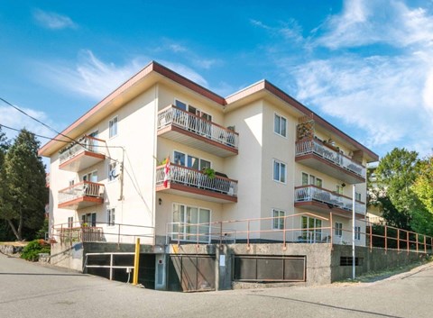 A white building with a red roof and balconies.