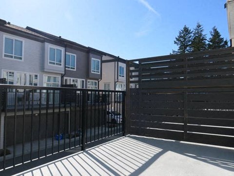 A black metal fence with a gate is in front of a building.