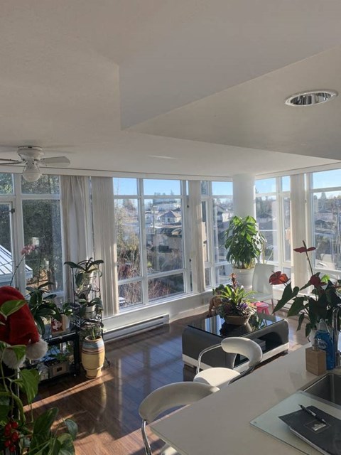 A kitchen with a table and chairs and a window with a view of the city.