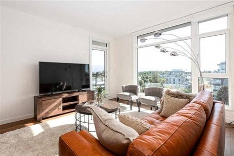 A living room with a brown leather couch and a flat screen TV.