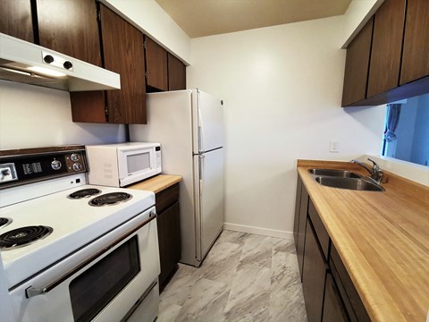 a kitchen with white appliances and wooden counter tops