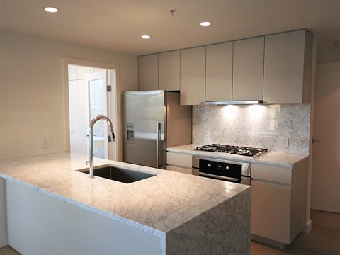 a kitchen with marble counter tops and stainless steel appliances