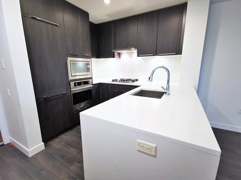 a kitchen with black cabinets and a white counter top