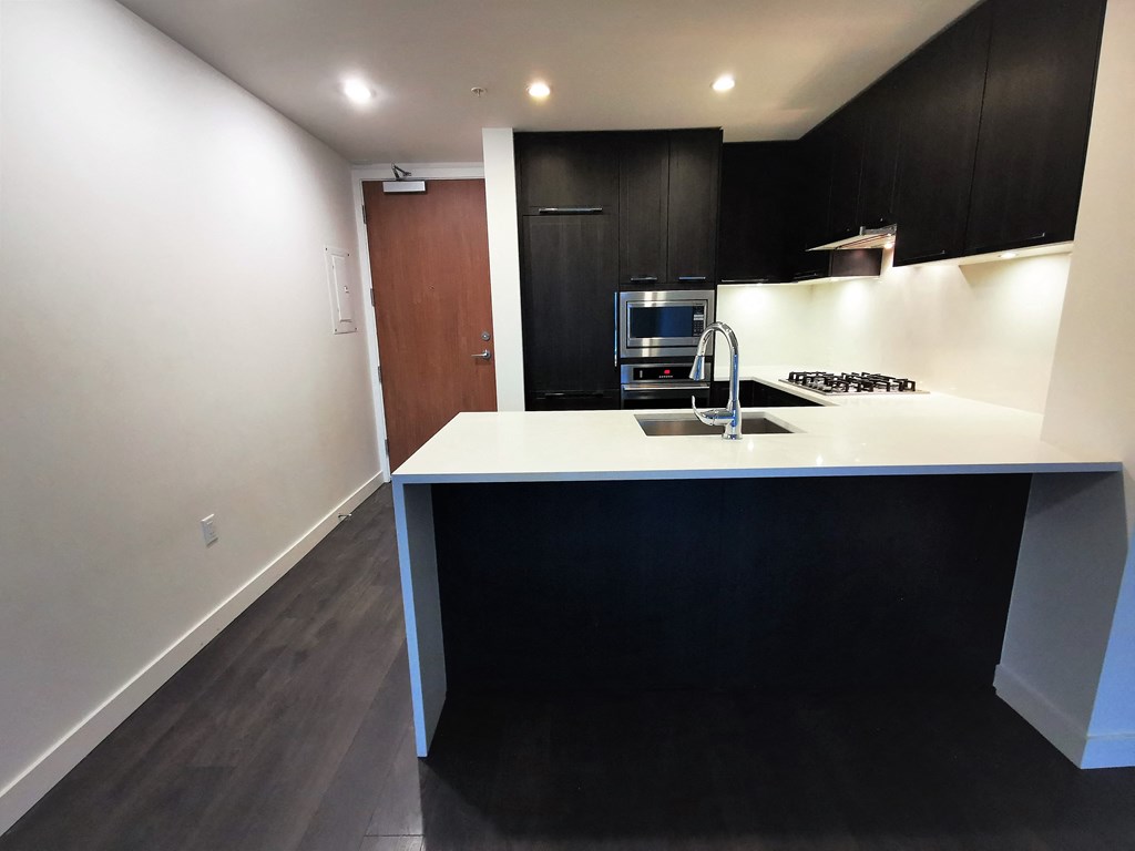 a kitchen with black cabinets and a white counter top