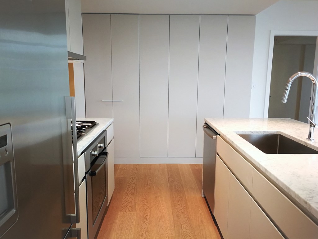 a kitchen with white cabinets and stainless steel appliances and a sink