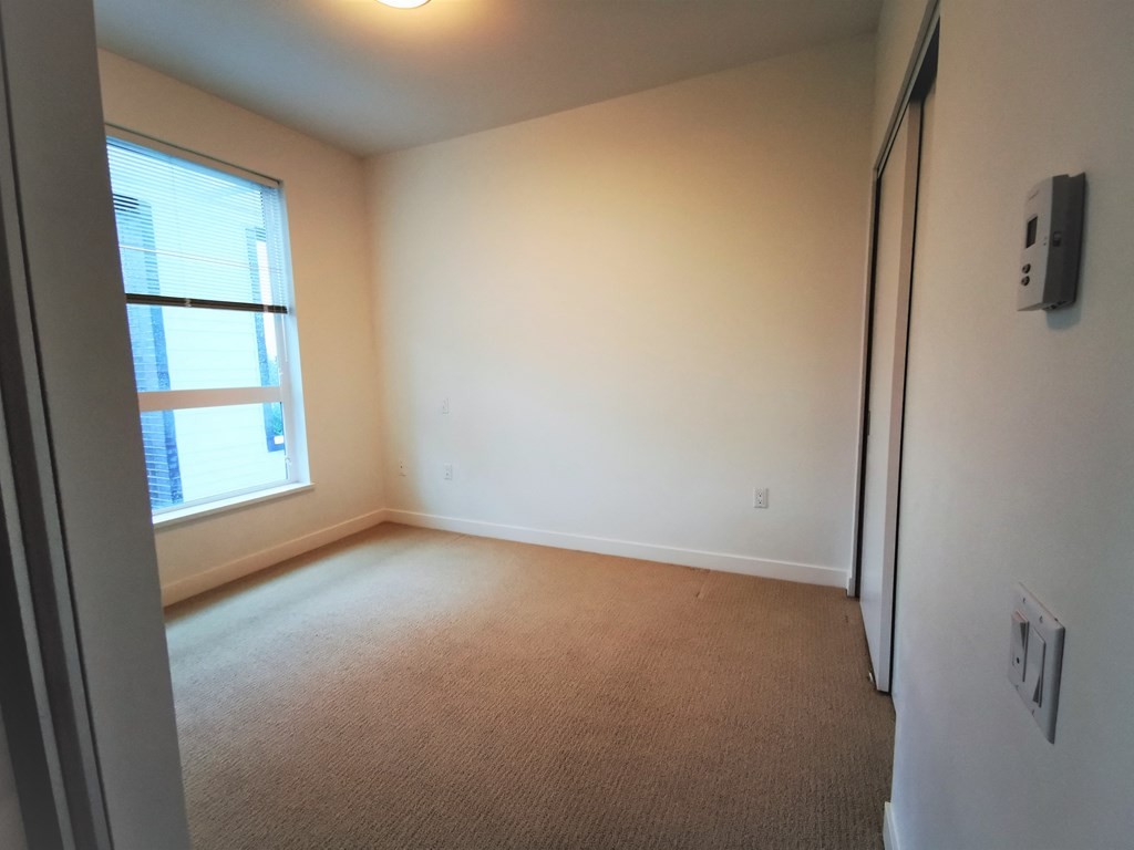 an empty room with a window and a door