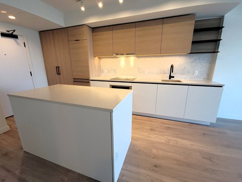 A kitchen with a white counter and wooden cabinets.