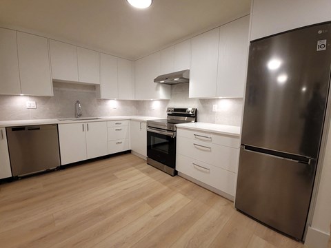 a kitchen with white cabinets and stainless steel appliances