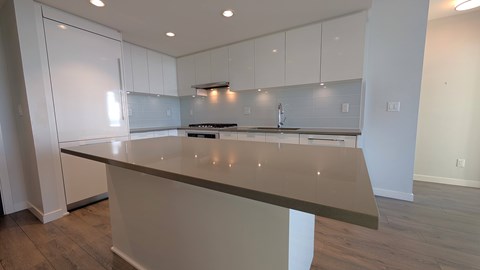 A kitchen with white cabinets and a countertop.