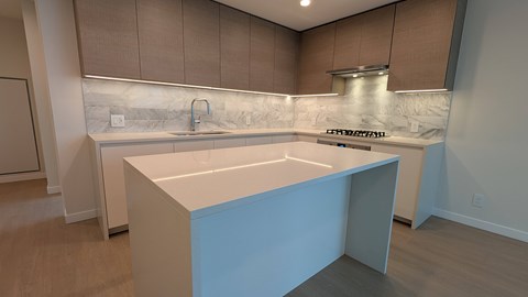 A kitchen with a white countertop and brown cabinets.