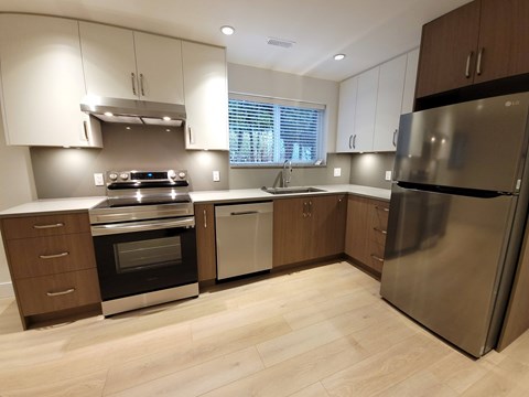 A modern kitchen with stainless steel appliances and wooden cabinets.