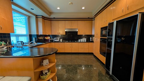 A kitchen with wooden cabinets and black appliances.