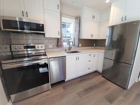 A kitchen with white cabinets and stainless steel appliances.