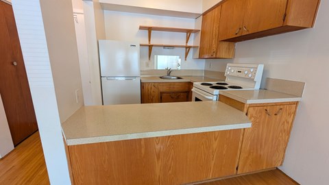 A kitchen with wooden cabinets and a white countertop.