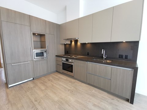 A modern kitchen with wooden cabinets and a stainless steel oven.