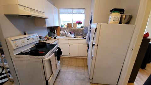 A kitchen with a white oven and refrigerator.