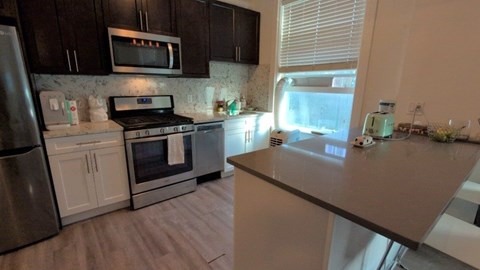 A kitchen with a stove, oven, refrigerator, and microwave.