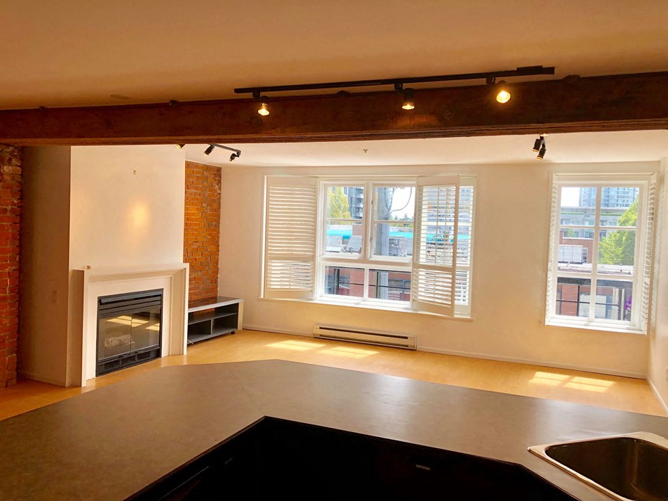 an empty living room with a fireplace and a sink