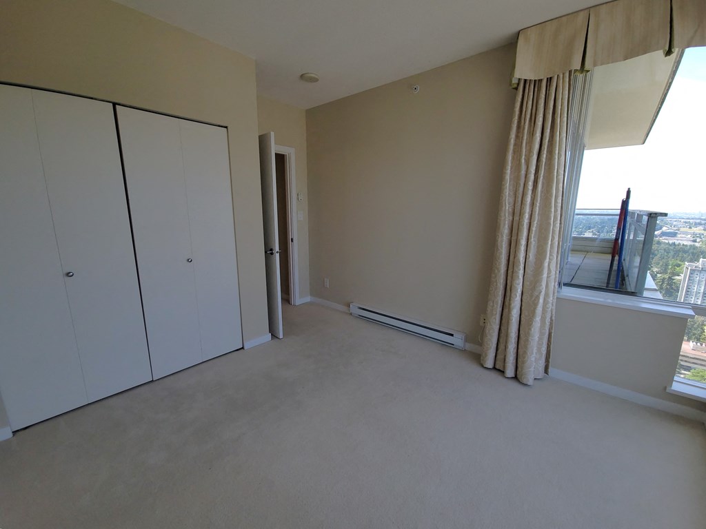 an empty living room with white cabinets and a window