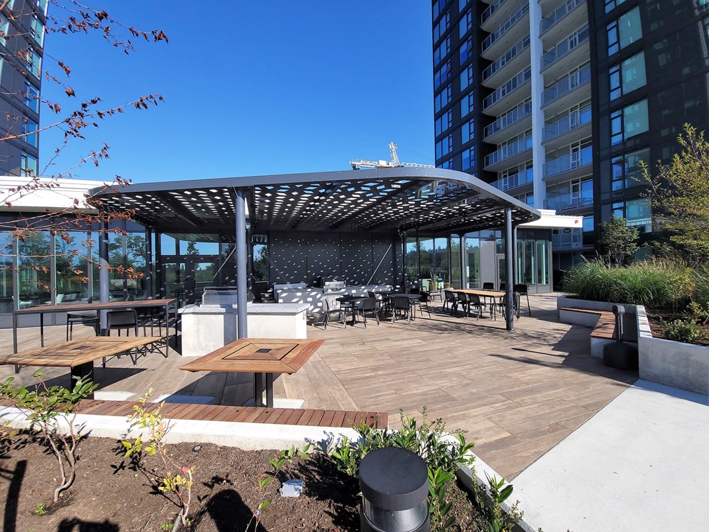 a patio area with tables and benches and a building in the background