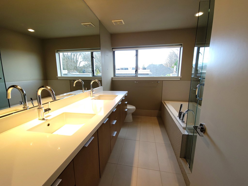 A bathroom with two sinks and a large mirror.