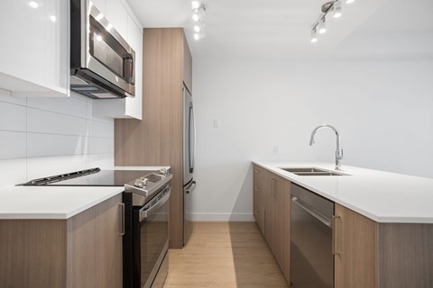 A modern kitchen with wooden cabinets and stainless steel appliances.