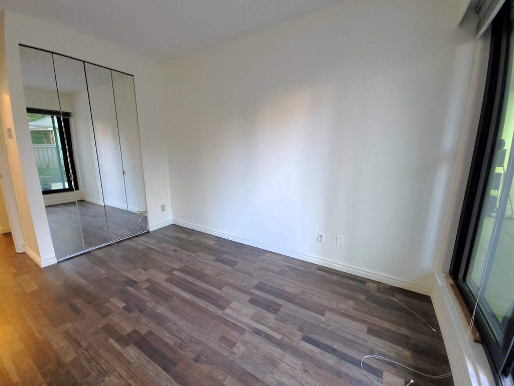 a living room with wood flooring and a large mirror