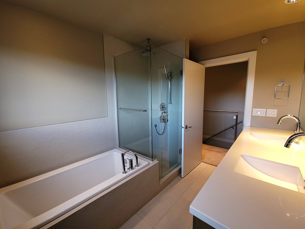 A bathroom with a white tub and sink.