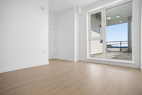 A room with a sliding glass door leading to a balcony.