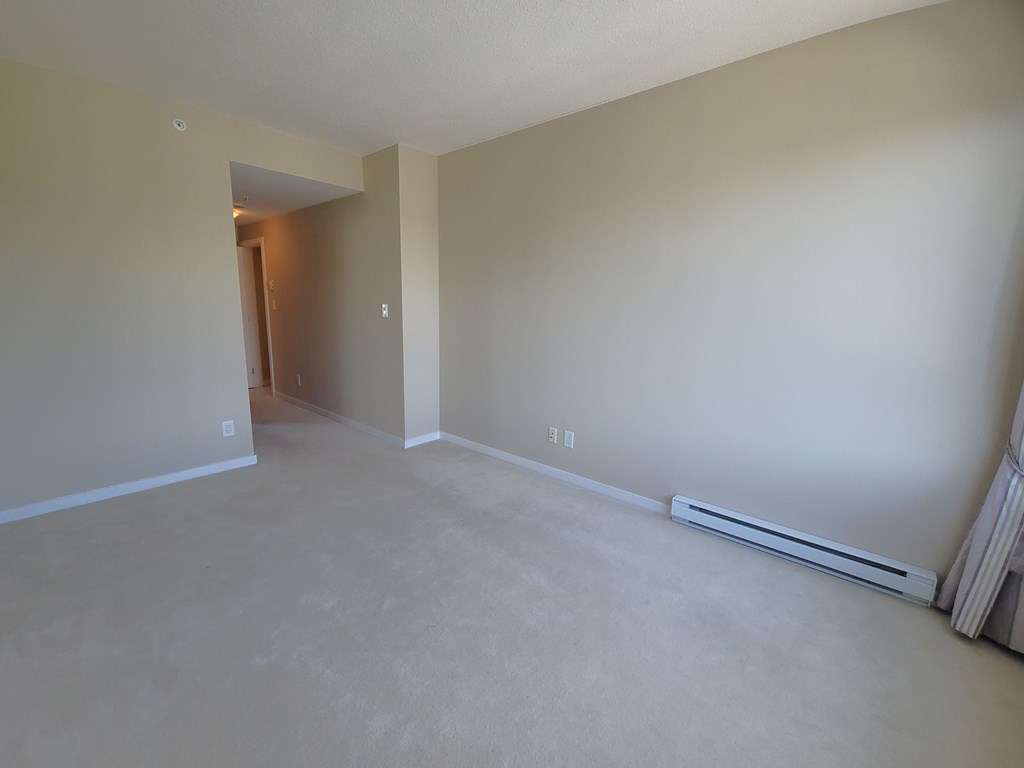 an empty living room with a heater on the floor