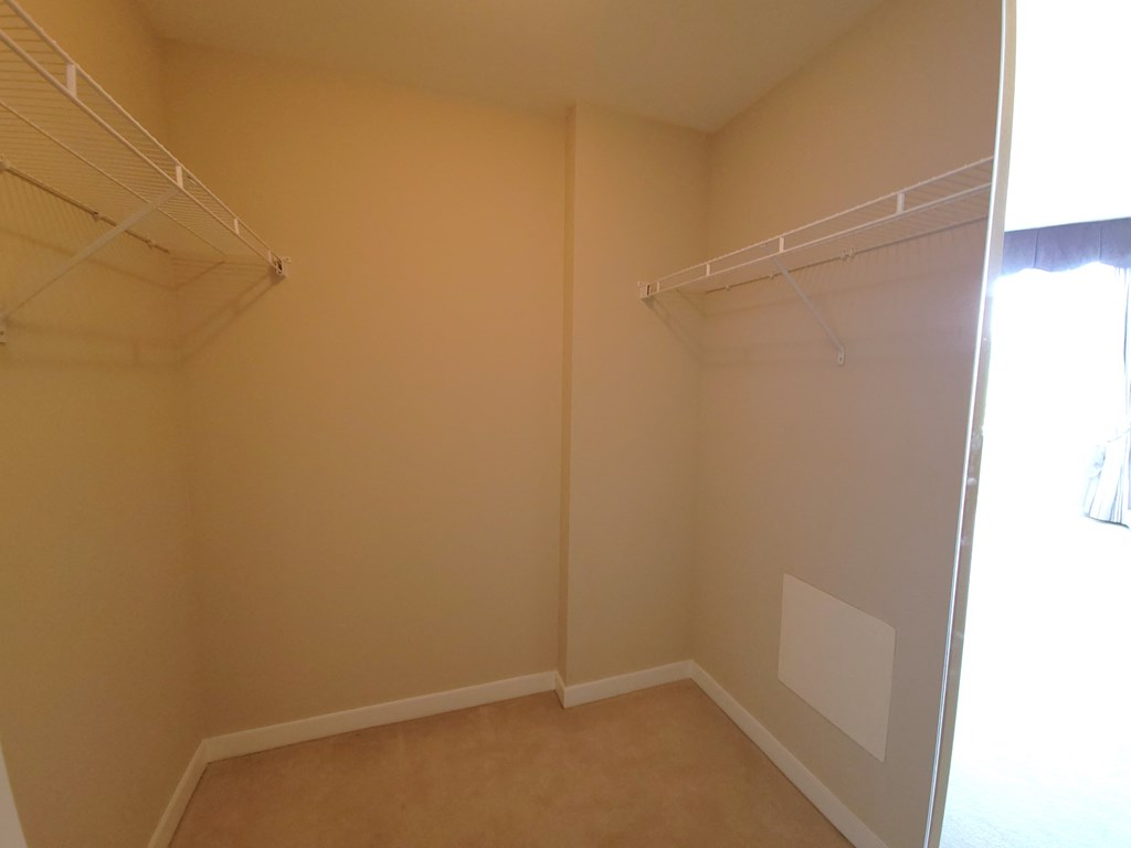 an empty bedroom with a closet and a window