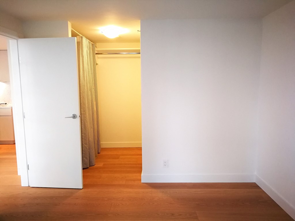 an empty living room with a door open to a hallway