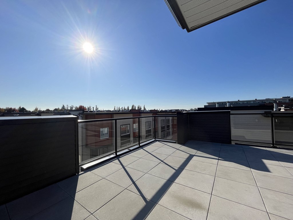 a balcony with a view of the sun and a blue sky