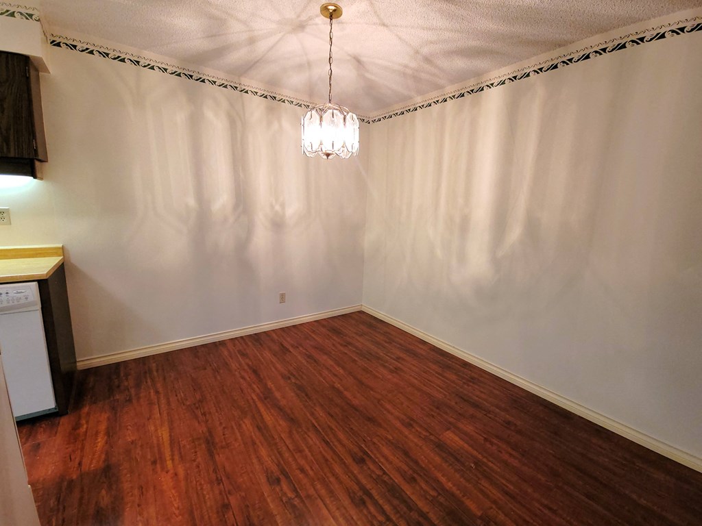 a bedroom with white walls and a wood floor