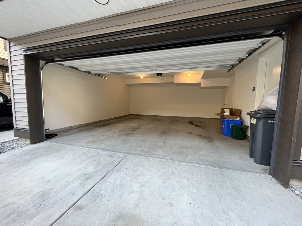 the garage door is open and the room is empty