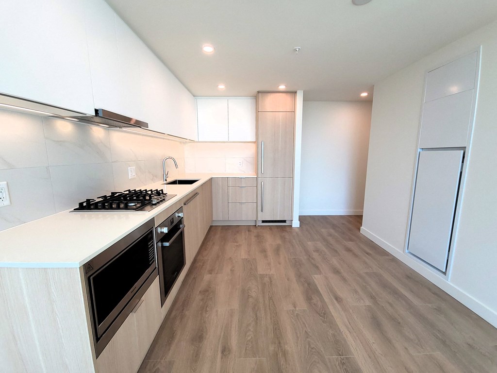 a renovated kitchen with white cabinets and stainless steel appliances