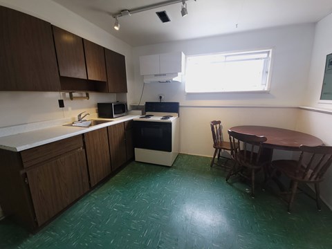 A kitchen with a table and chairs.
