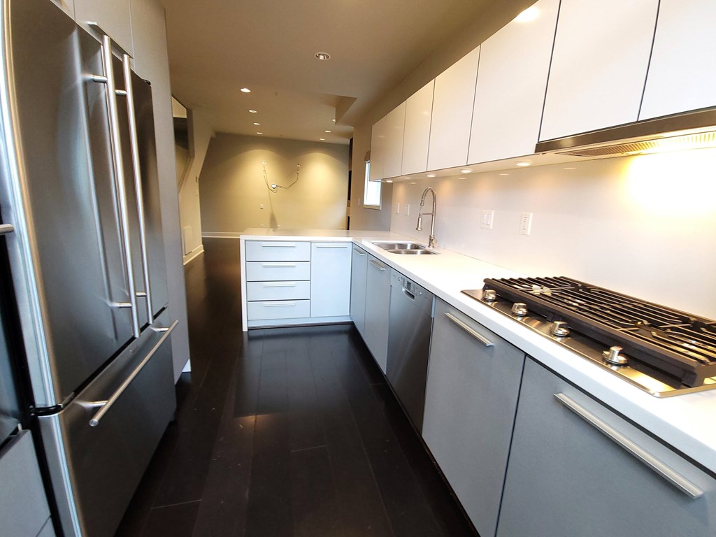 A modern kitchen with stainless steel appliances and white cabinets.