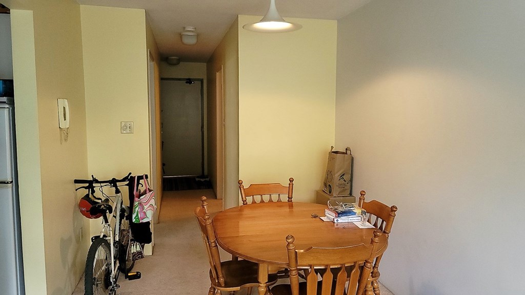 A dining room with a table and chairs.