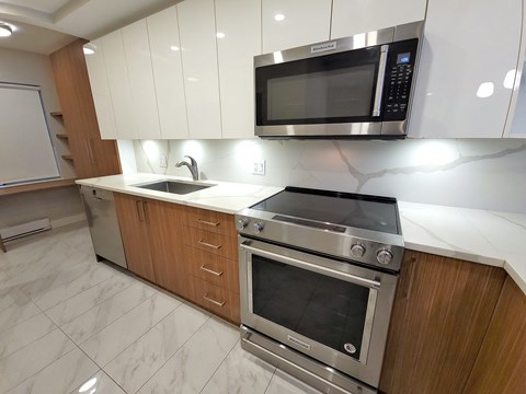 A modern kitchen with a stainless steel oven and microwave.
