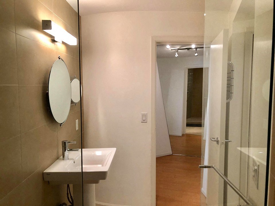a bathroom with a sink and a mirror and a shower