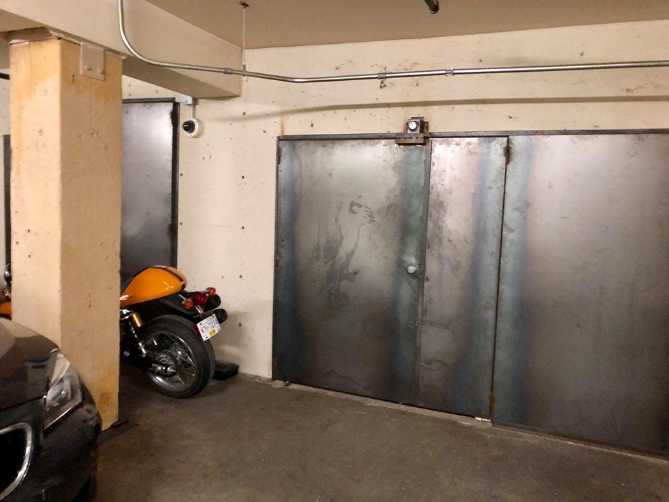 a motorcycle parked in a garage next to two metal doors