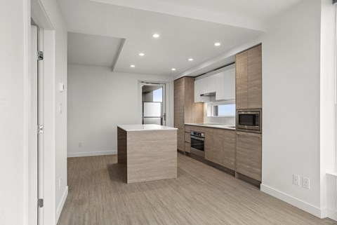 A modern kitchen with wooden cabinets and a central island.