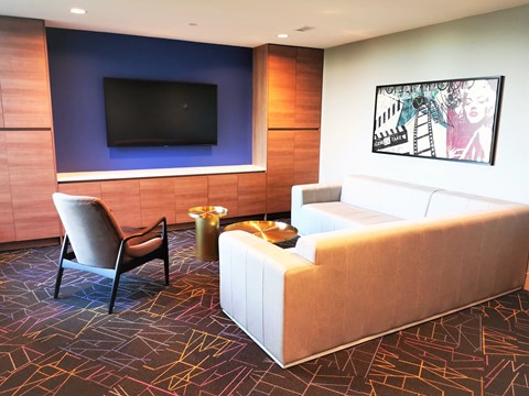 A living room with a white couch, a chair, and a television.