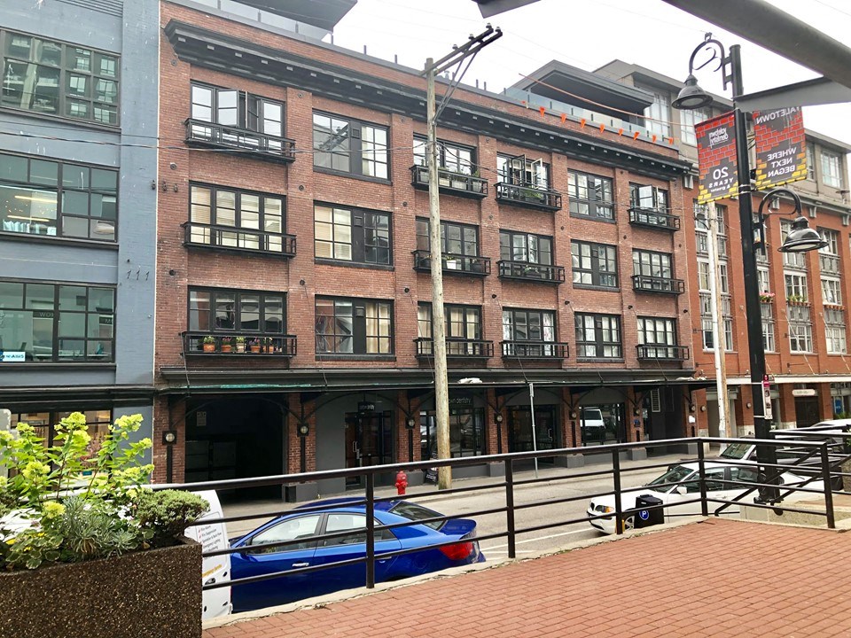 a large brick building with a blue car parked in front of it