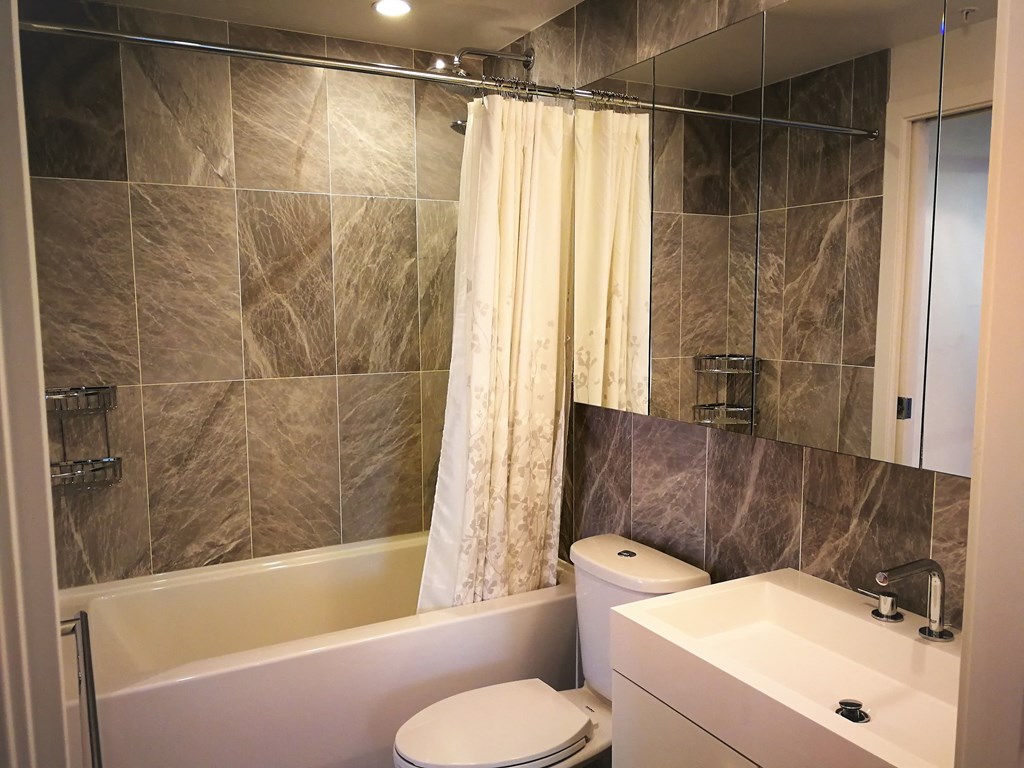 a bathroom with a shower and a toilet and a sink