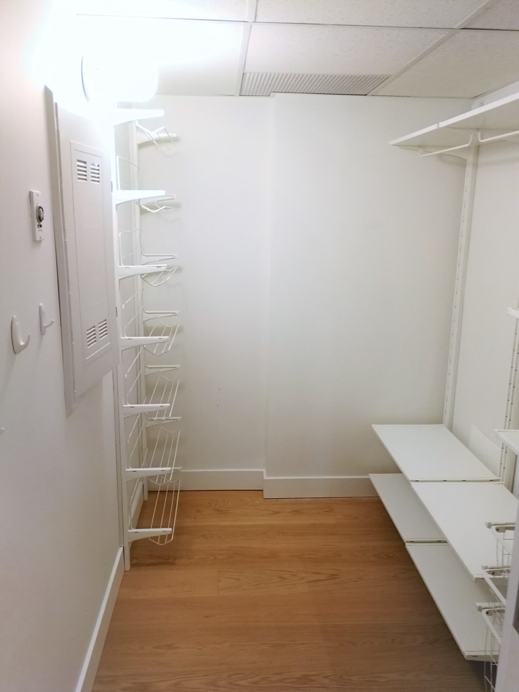 a room with white shelves and a ladder on the wall