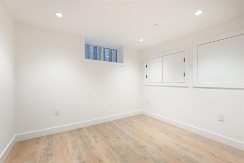 A room with wooden flooring and white walls.