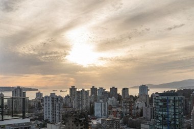 a city skyline with the sun low in the sky