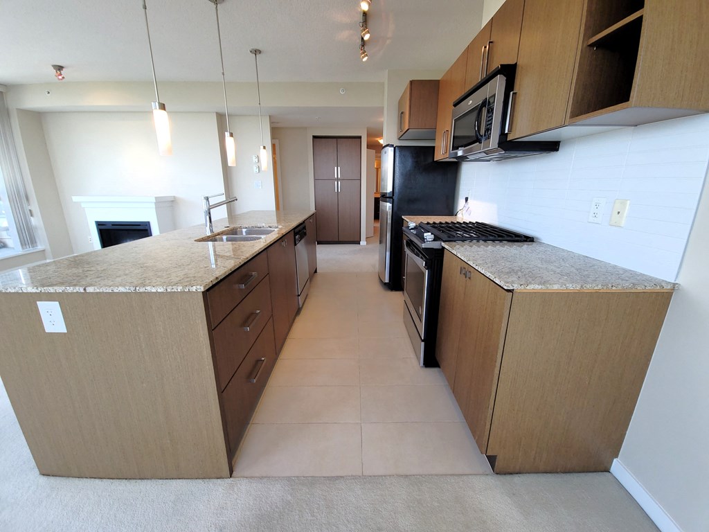 a kitchen with an island and a stove and a refrigerator